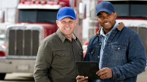 Two truck drivers reviewing a tablet together